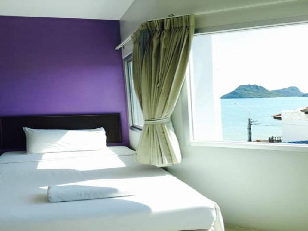 班武里府巴蜀海滩酒店的一间卧室设有两张床和窗户。