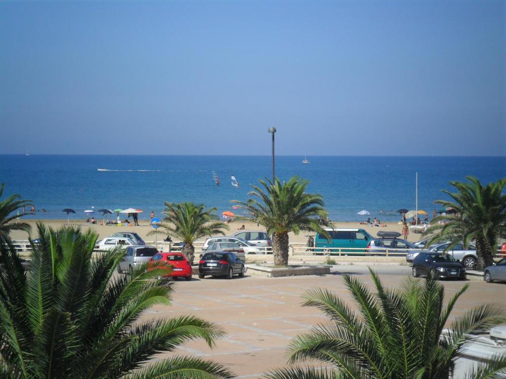 维耶斯泰Appartamenti Bramante的棕榈树和海洋海滩上的停车场