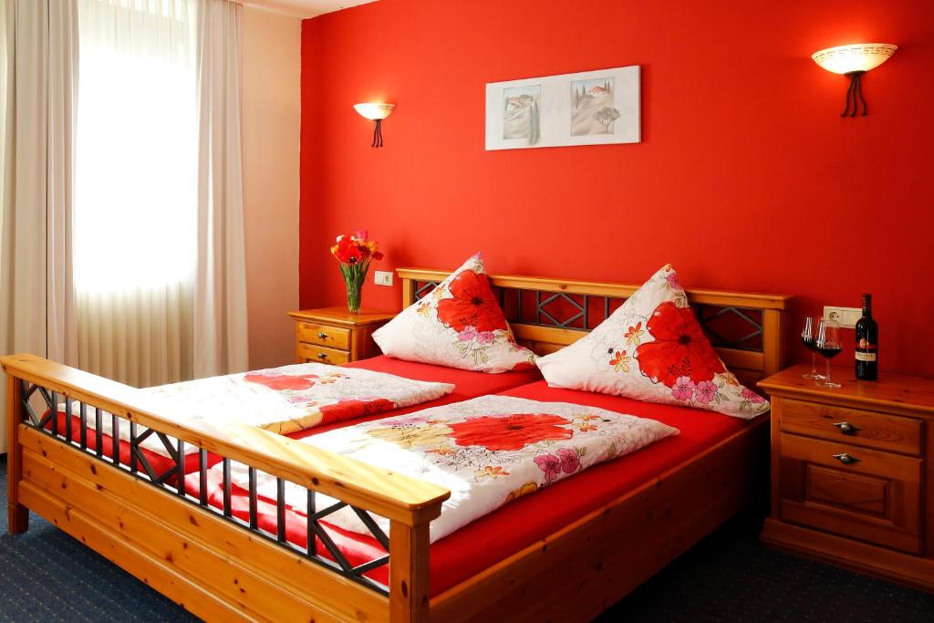 山麓魏森海姆Hotel & Restaurant Weisenheimer Hof的一间卧室配有红色墙壁的床