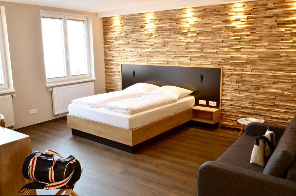 纽伦堡Hotel FIVE的一间卧室设有一张床和砖墙