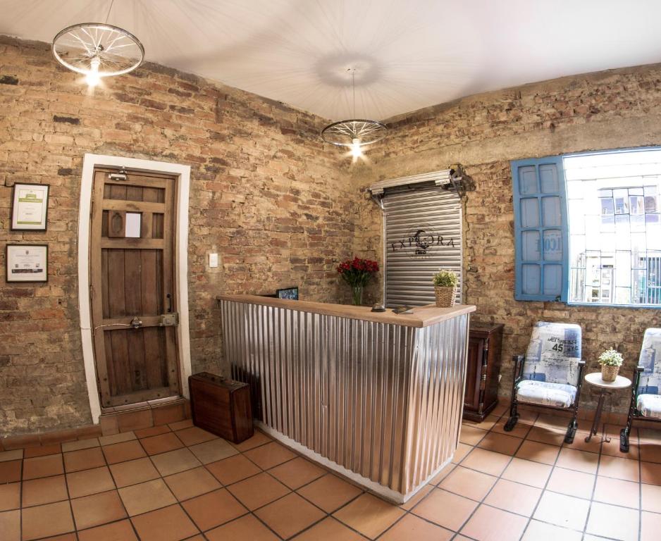 波哥大探索酒店的一间设有砖墙和桌椅的房间