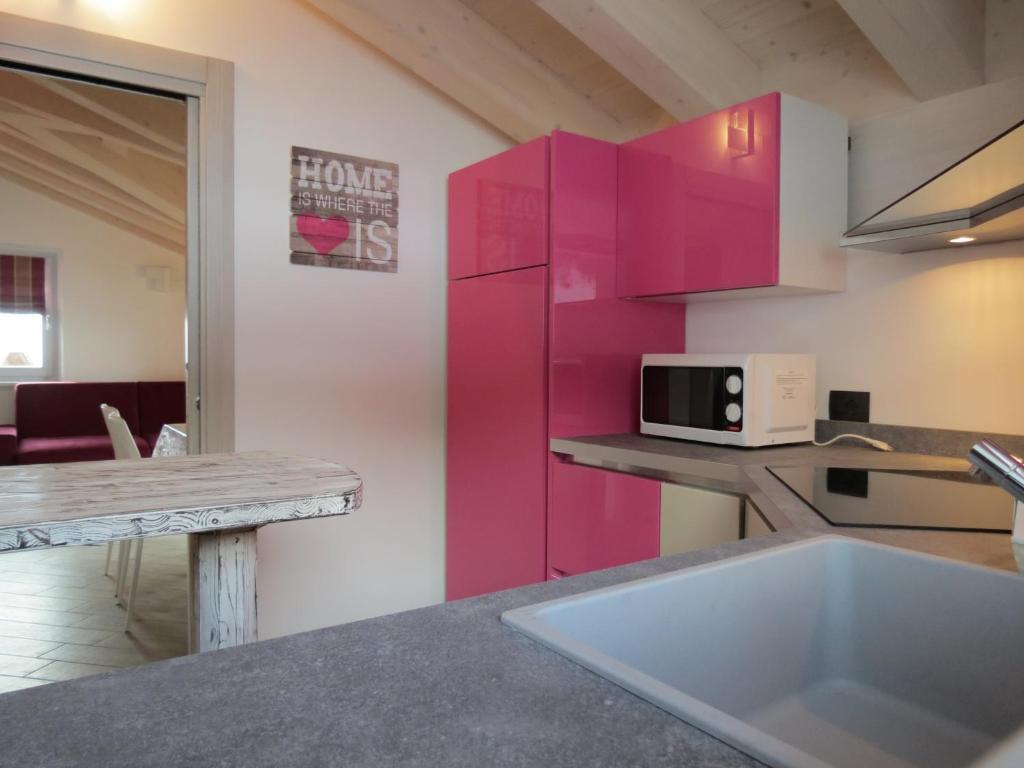 利维尼奥Al Dos的厨房配有粉色橱柜和厨房水槽