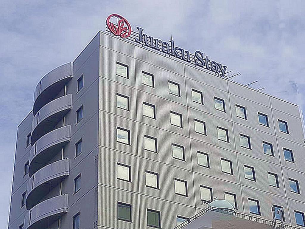 新泻新泻聚乐经济型酒店的上面有标志的建筑