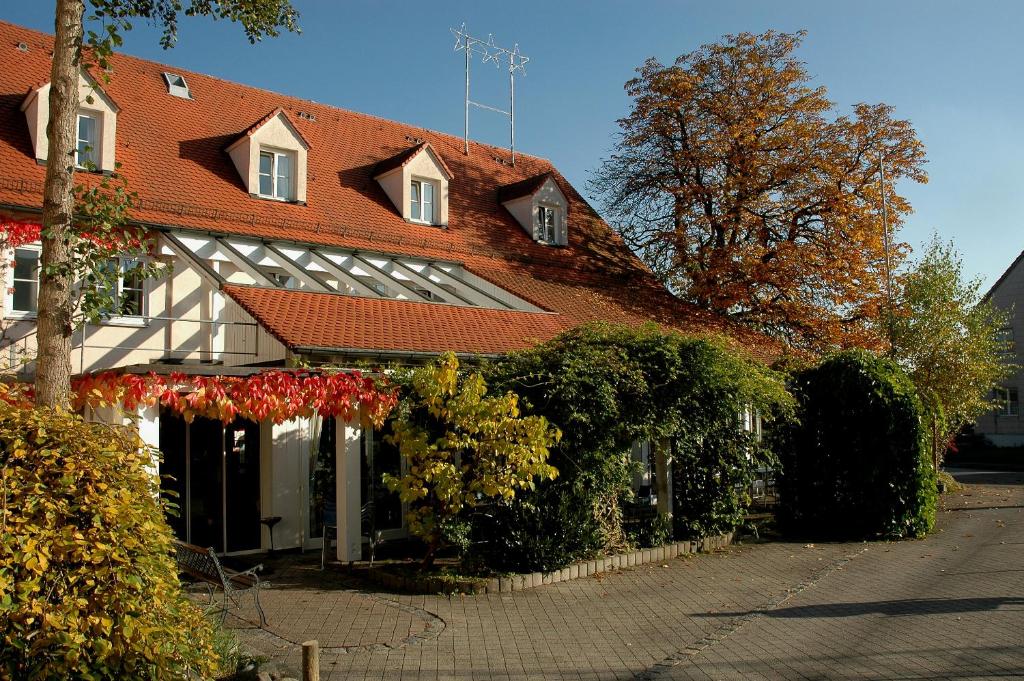 乌尔姆恩格尔酒店的一座大型建筑,有红色的屋顶和灌木丛
