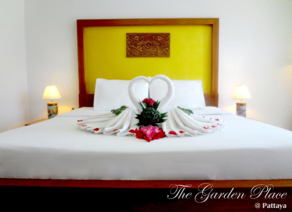 芭堤雅市中心芭堤雅花园广场公寓的床上的新娘和新郎的婚纱