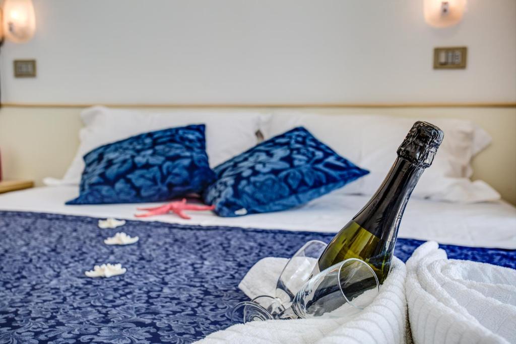 里米尼提兹亚娜酒店的床上坐着一瓶葡萄酒