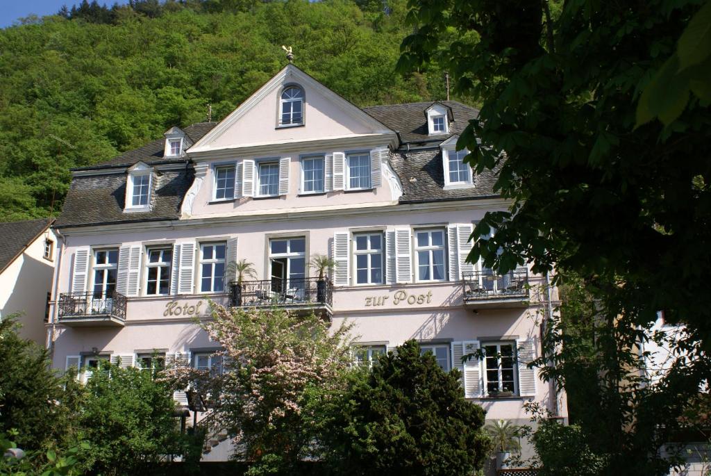布罗登巴赫苏尔波斯特罗曼蒂克丝酒店的白色的大房子,有白色的窗户和树木