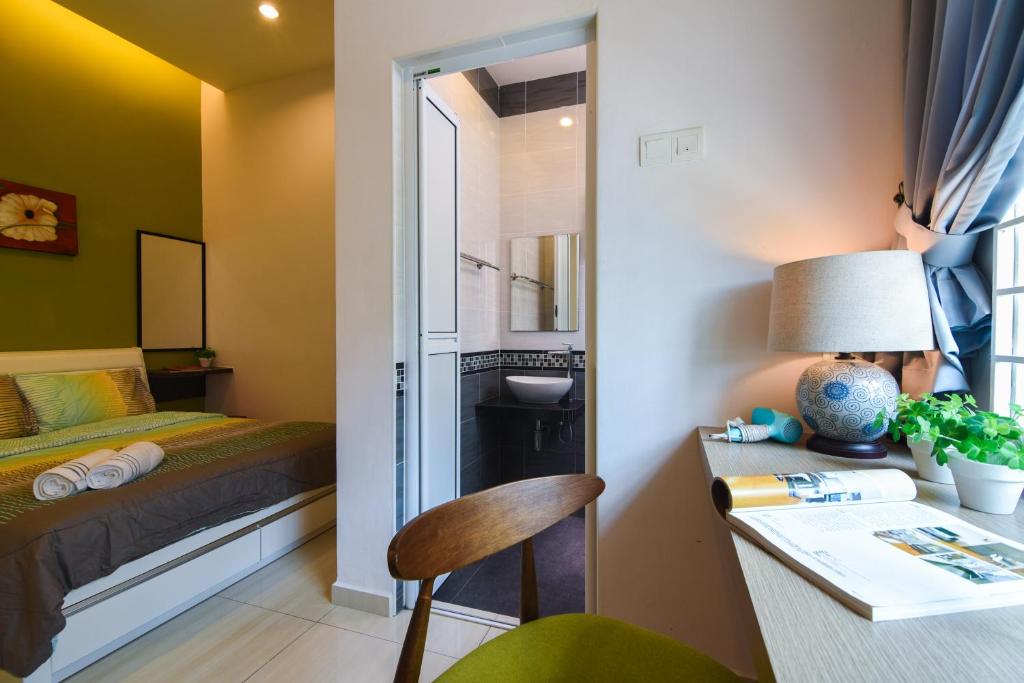 马六甲马六甲萨福隆住宿酒店的小房间设有一张床和一张带台灯的桌子