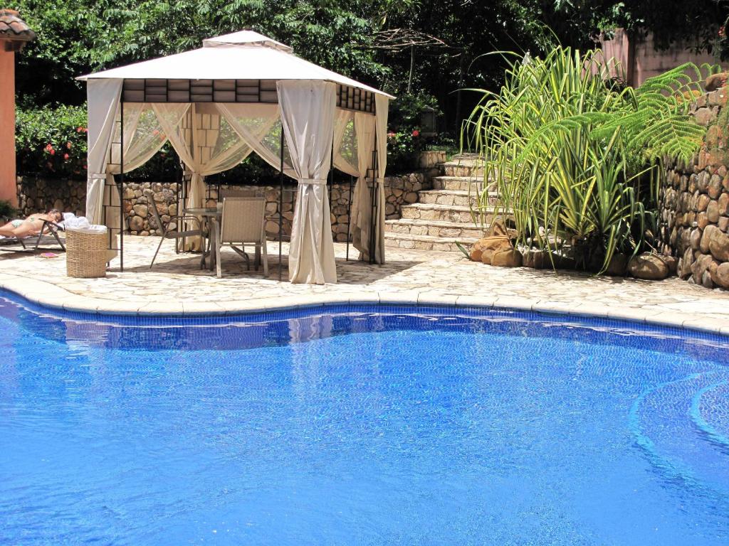 SuchitotoLos Almendros de San Lorenzo的一个带遮阳伞和凉亭的游泳池
