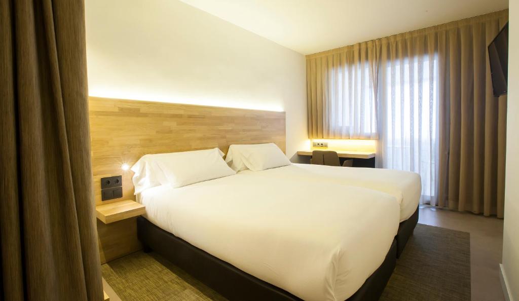 潘普洛纳潘普洛纳酒店的酒店客房设有一张白色大床和一个窗户。