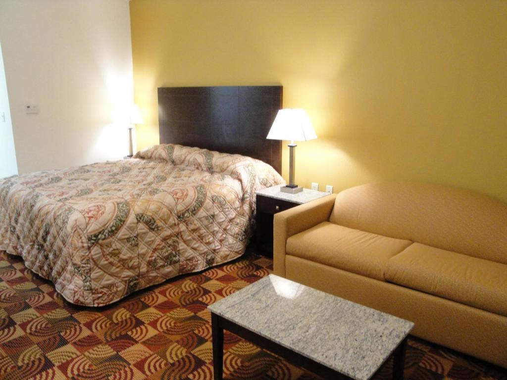 WoodwardSands Inn & Suites的酒店客房,配有床和沙发