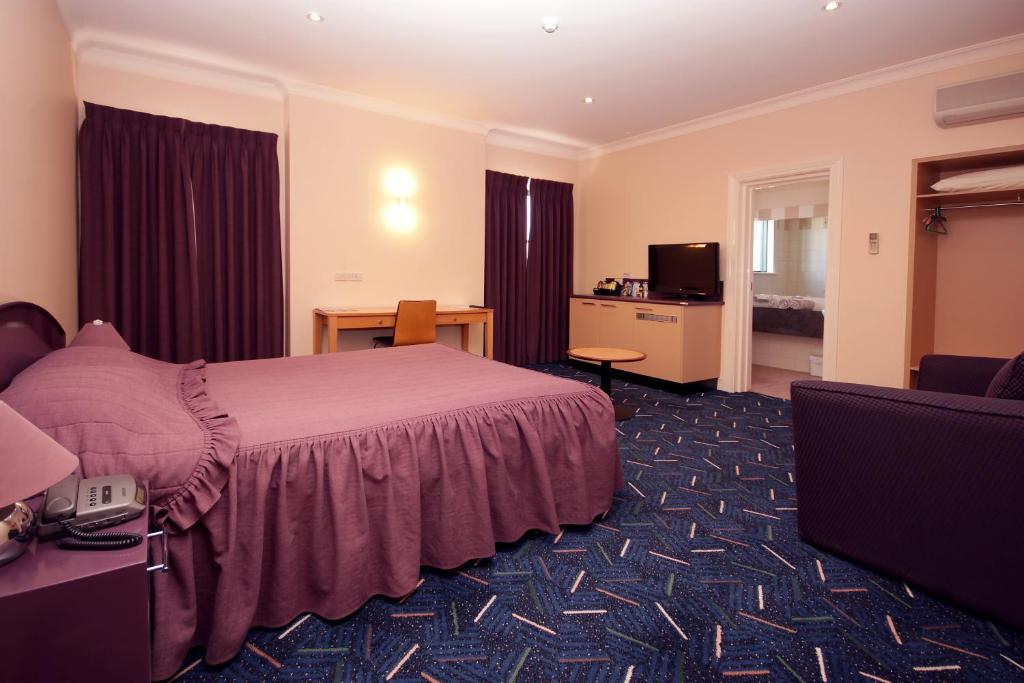 拜恩斯代尔米切尔河客栈 的酒店客房,配有床和电视