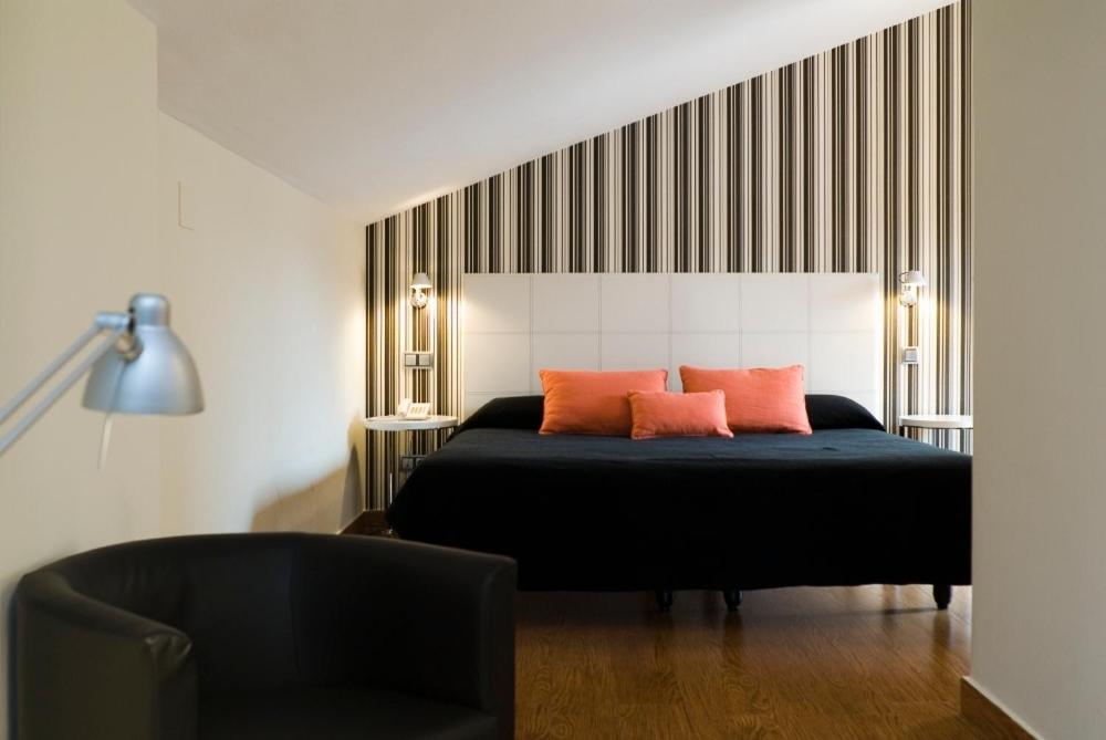 达罗卡阿尔穆迪旅馆的一间卧室配有黑色床和两个橙色枕头