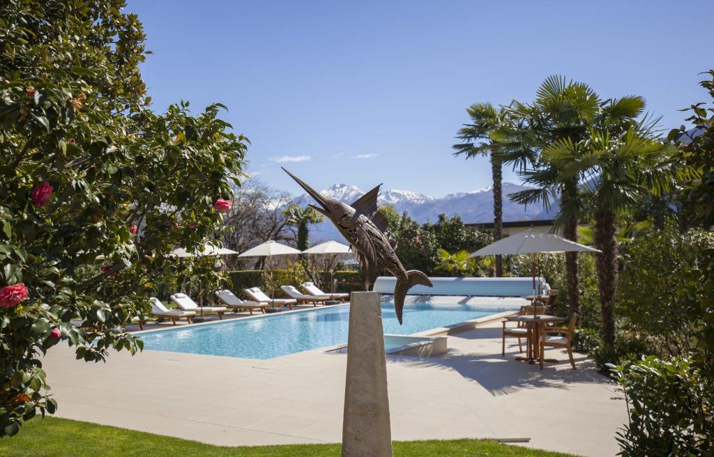 洛迦诺Boutique-HOTEL REMORINO, a Private Selection Hotel的一座位于游泳池旁的鸟雕像