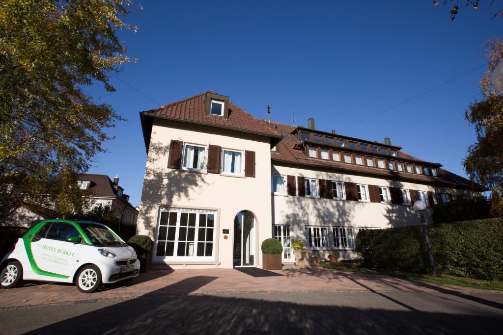 费尔巴赫布克勒酒店的前面有一辆汽车停放的白色房子
