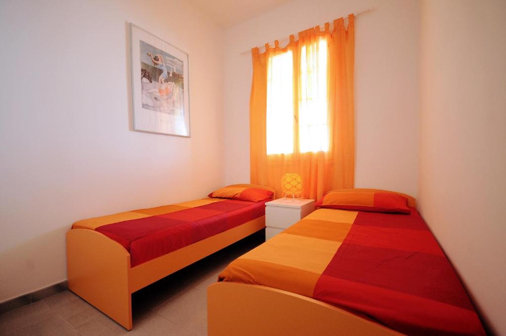加利波利Baia Verde Apartments的带窗户的客房内的两张床