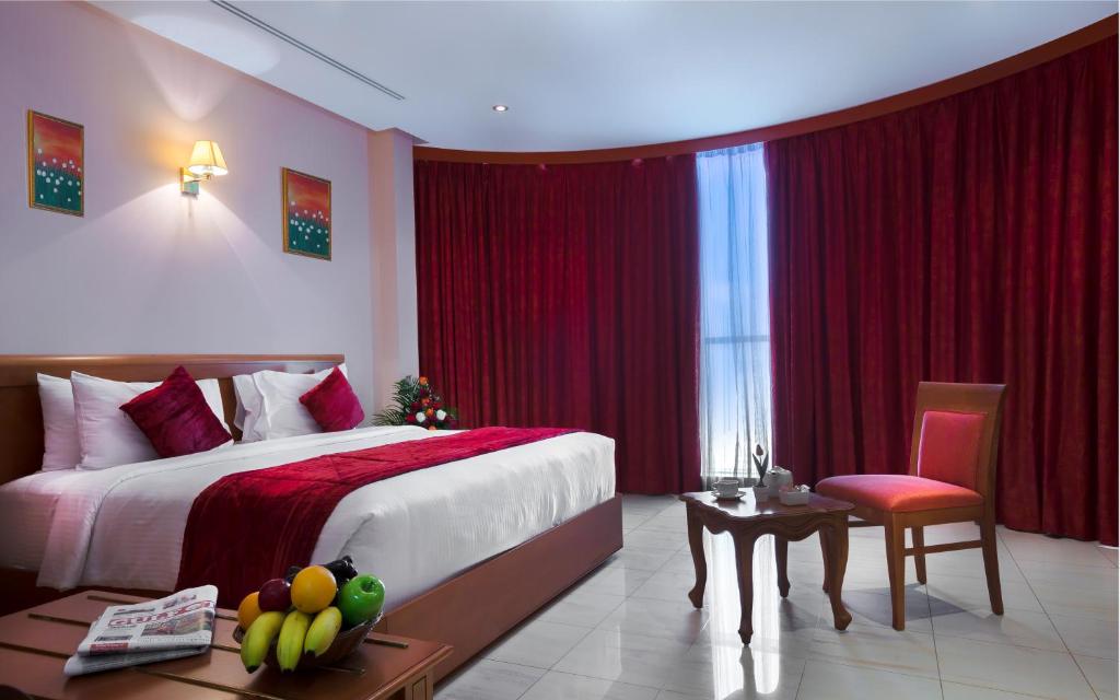 多哈多哈玛迪娜套房酒店的卧室配有1张床、1张桌子和1把椅子