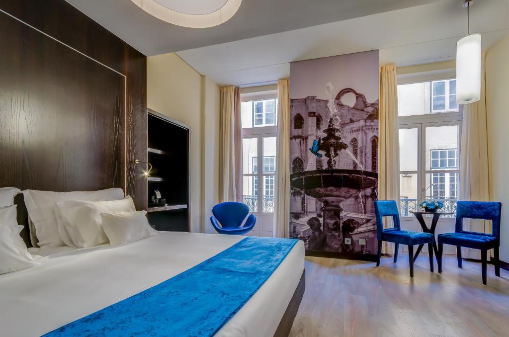 里斯本里斯本BE酒店的一间卧室配有一张大床和蓝色的椅子
