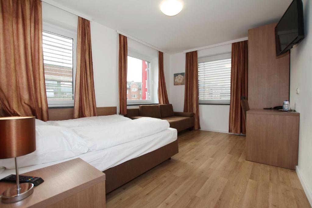 汉堡艾姆桑德公寓酒店的酒店客房带床、沙发和窗户
