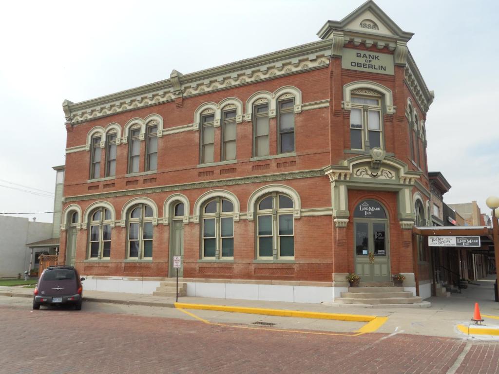 OberlinLandMark Inn at the Historic Bank of Oberlin的一座红砖建筑,前面有一辆汽车