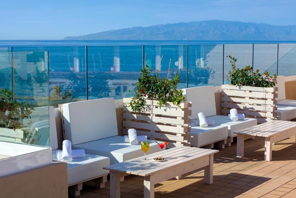 圣地亚哥港德拉格斯苏尔公寓酒店的阳台上的一排桌子和长椅