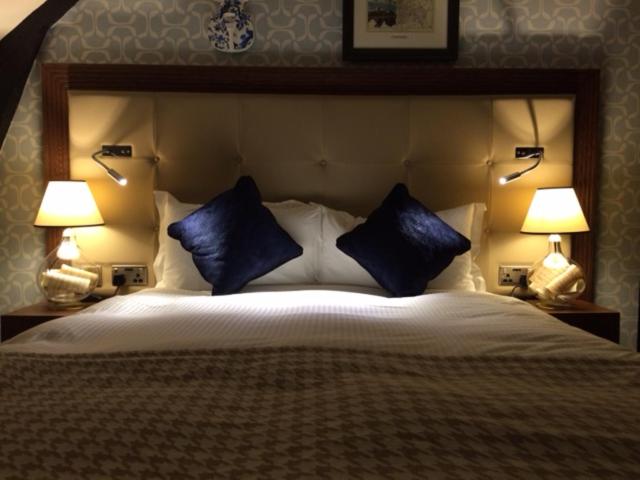 伍斯特The Crown Wetherspoon的一间卧室配有一张带蓝色枕头的大床