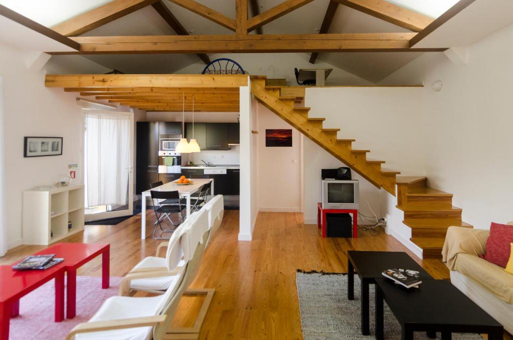 Rabo de PeixeSantana Houses的一间带木制天花板和楼梯的客厅