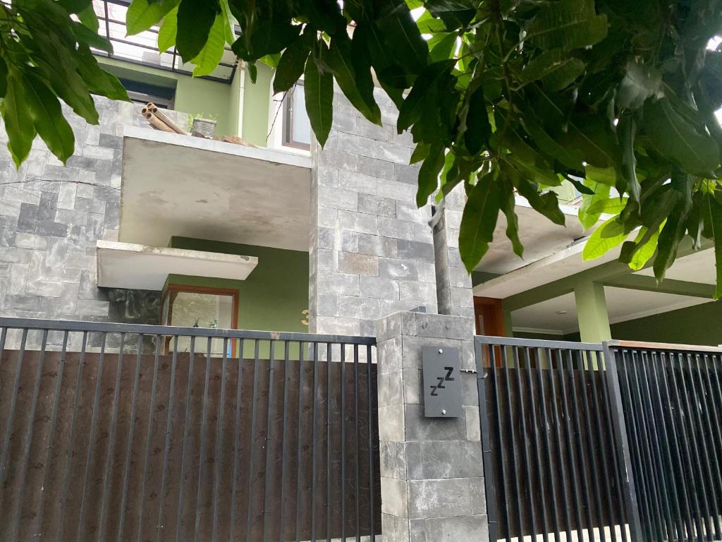 玛琅Zzz Hostel Malang的一座带门和栅栏的建筑