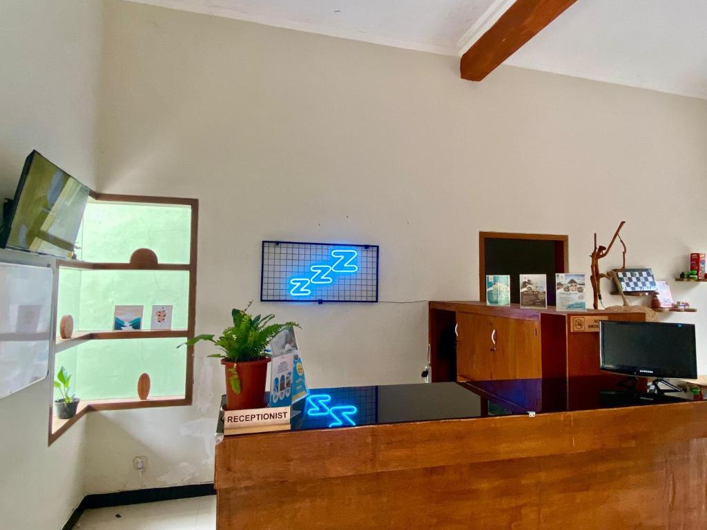 玛琅Zzz Hostel Malang的墙上有蓝色标牌的柜台的房间
