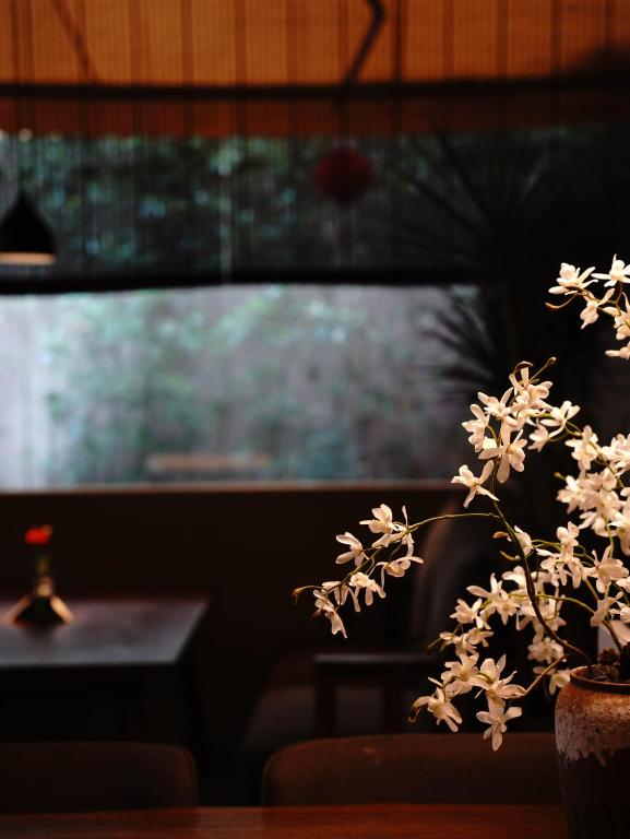 成都Chuanxing Yinli Hotel Chengdu Kuanzhai Alley Branch, with free welcome wine and afternoon tea的花瓶,花朵花朵花在桌子上