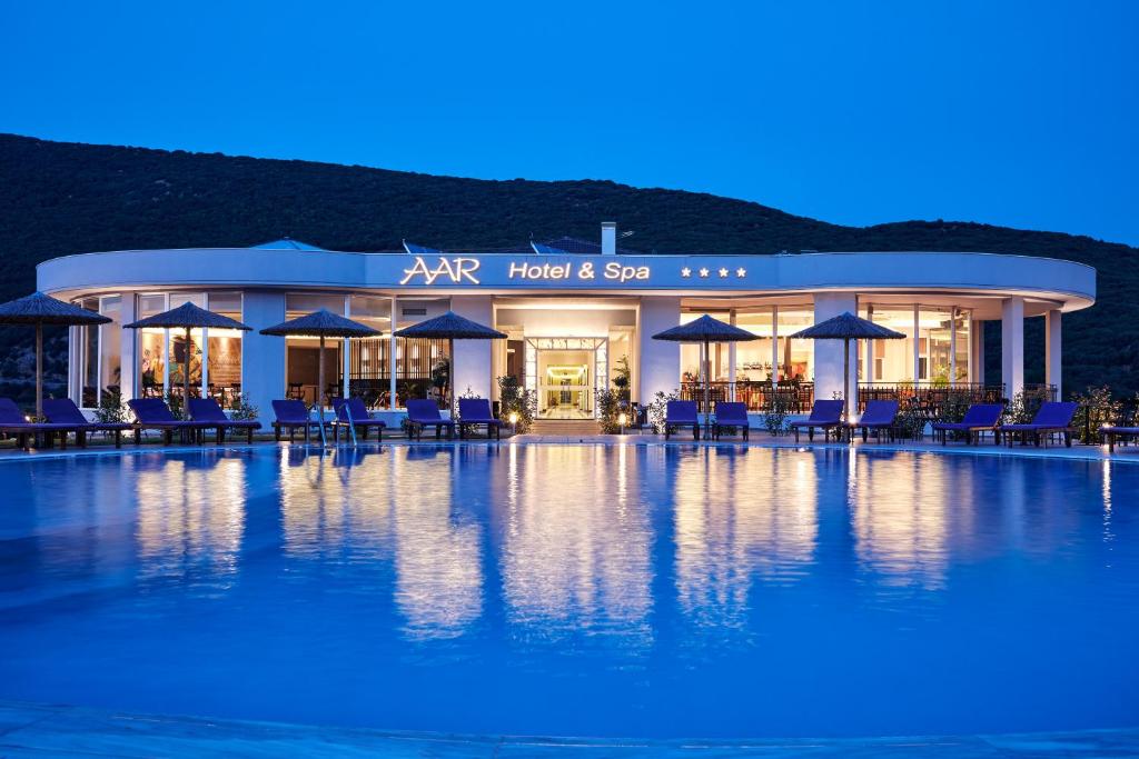 约阿尼纳Aar Hotel & Spa Ioannina的酒店前方的游泳池配有椅子和遮阳伞