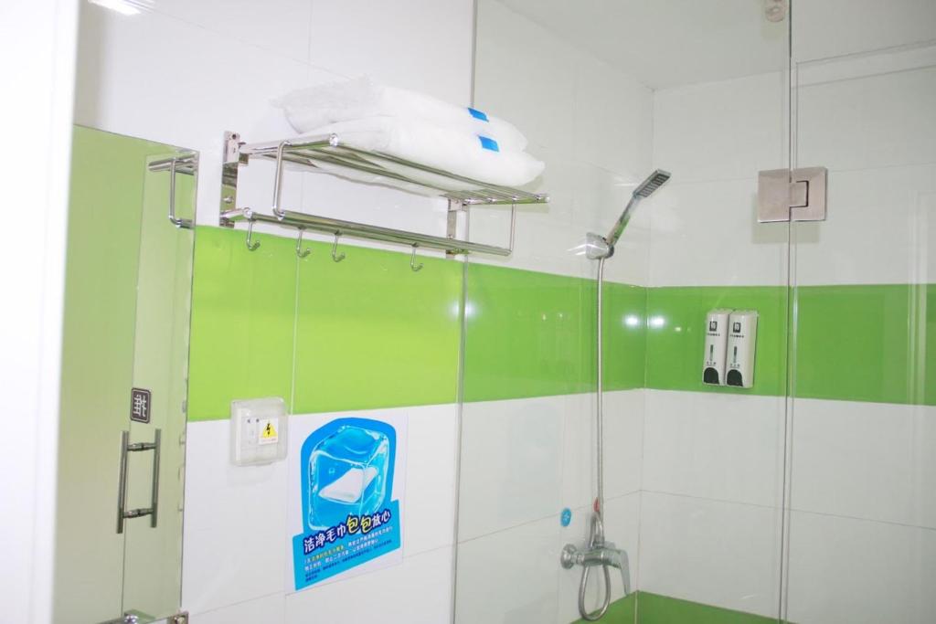 银川7天优品·银川火车站福州南街店的浴室设有绿色和白色的墙壁,配有淋浴。