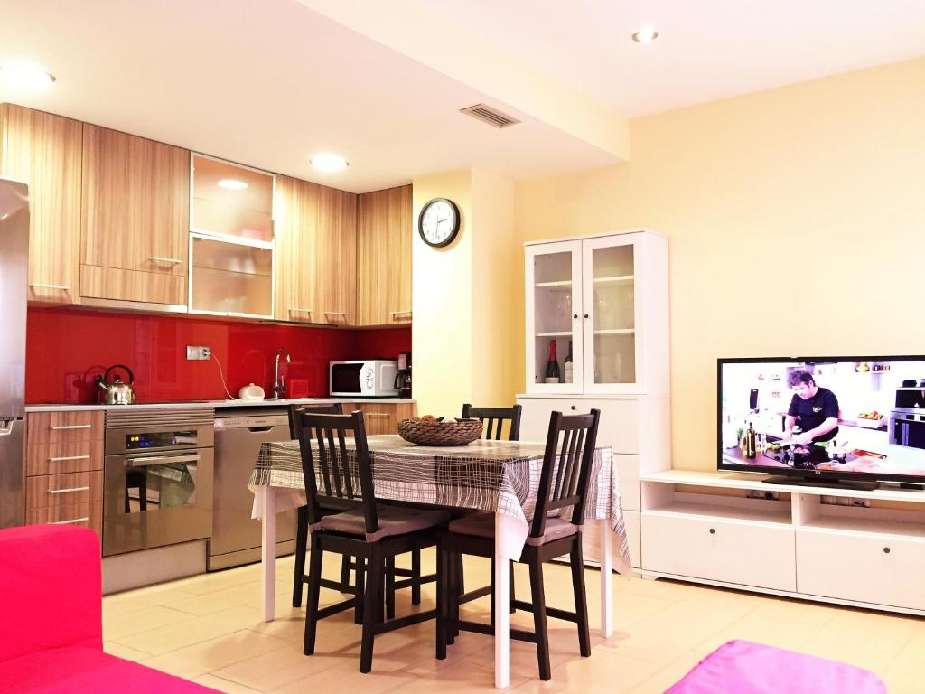 罗列特海岸略雷特海滩公寓 的厨房配有桌椅和电视。