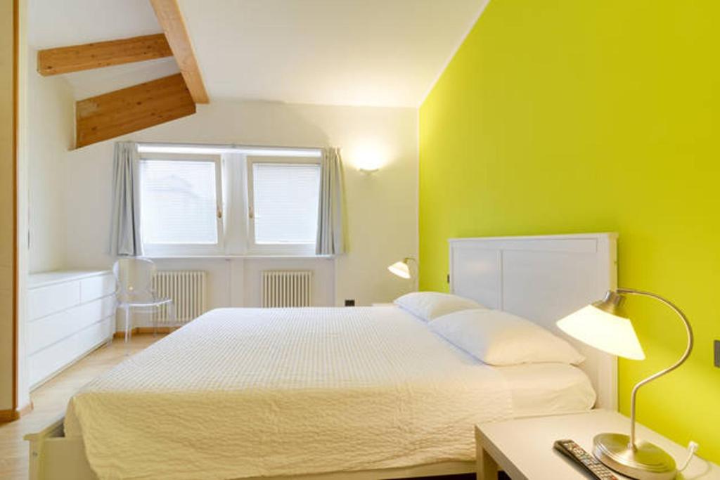 特伦托马尔法提宫住宿加早餐旅馆的卧室配有白色的床和绿色的墙壁