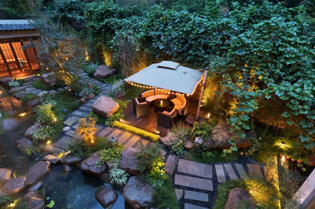 成都Chuanxing Yinli Hotel Chengdu Kuanzhai Alley Branch, with free welcome wine and afternoon tea的夜晚花园的顶部景色,灯光照亮