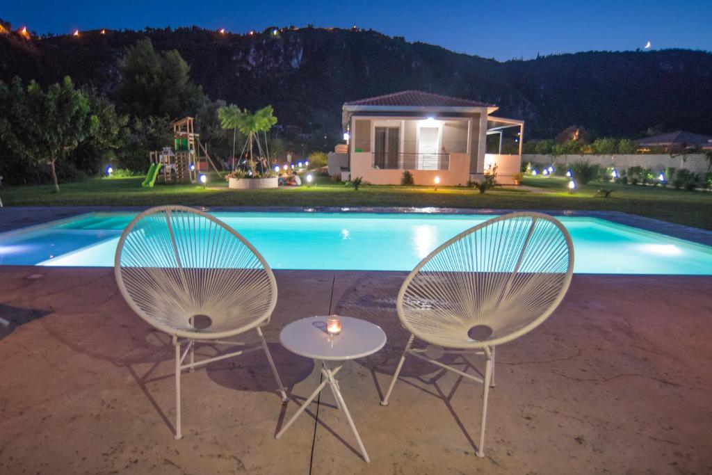 雷夫卡达镇Casa di Varco的游泳池前的两把椅子和一张桌子
