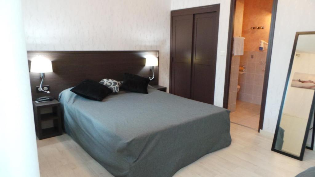 瑟堡莱纳桑斯酒店的一间卧室配有一张大床和两个枕头