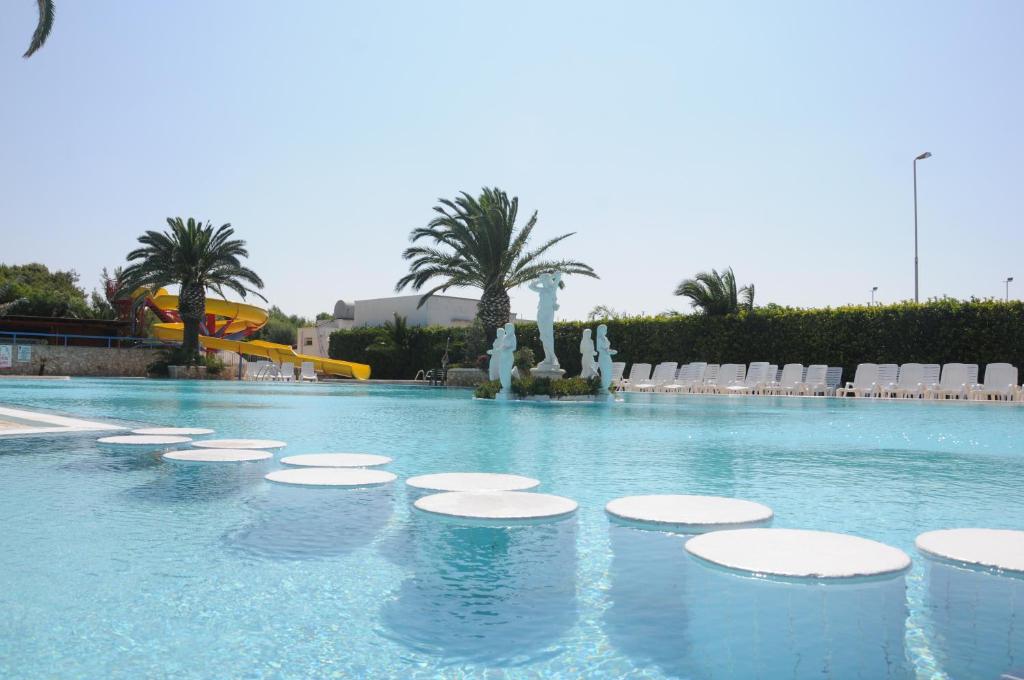 斯培基奥拉Camping Villaggio Pineta Al Mare的一个带椅子和棕榈树的大型游泳池