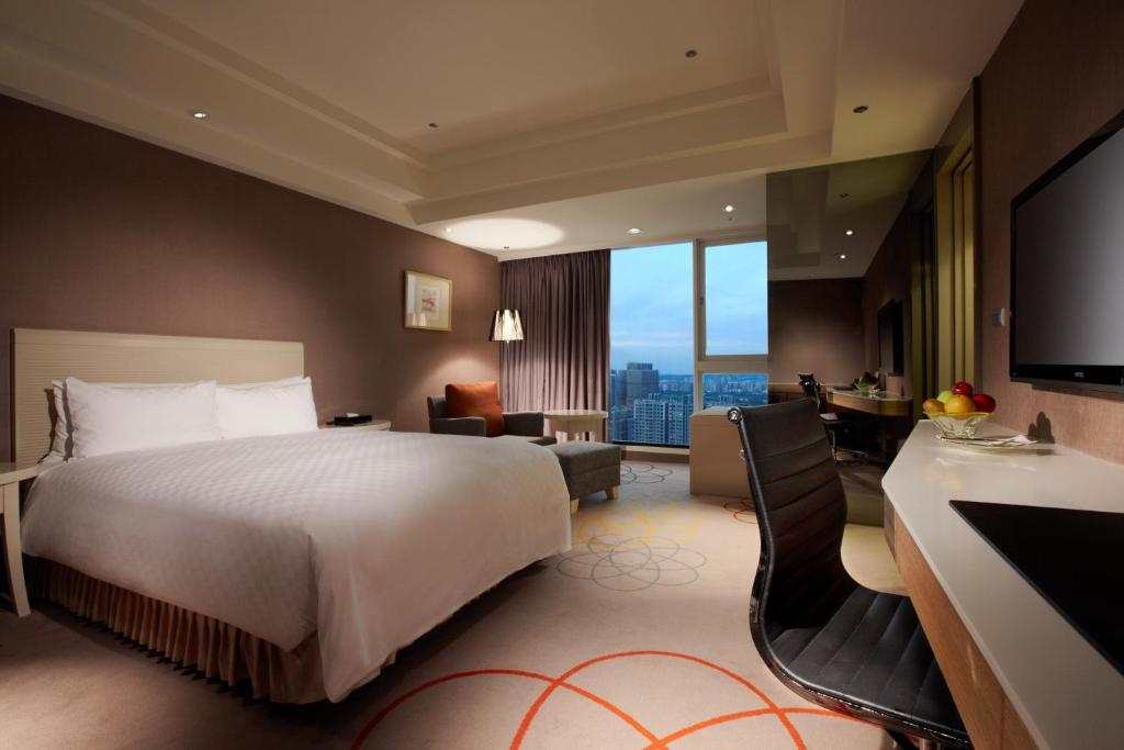 新竹新竹老爺酒店的酒店客房配有一张床和一张书桌及一台电视