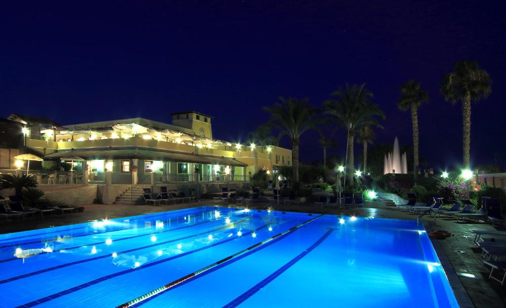 桑皮耶里iGV Club Baia Samuele的夜间游泳池,灯光照亮