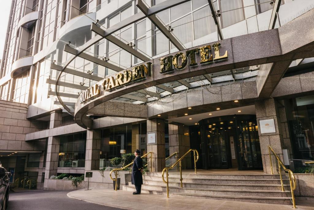 伦敦皇家花园酒店的一名男子站在一栋建筑物前