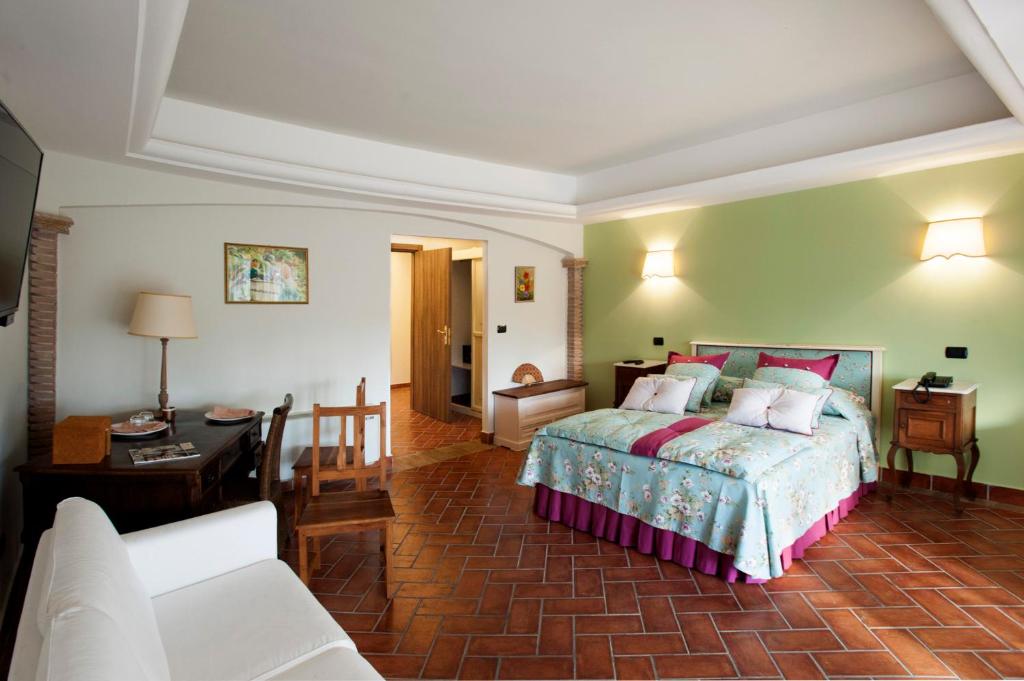 切普拉诺La Vignola Country Hotel的一间卧室设有一张床和一间客厅。