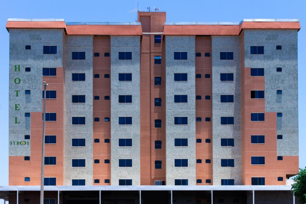 Gama锡罗斯酒店 的一座高大的建筑,有许多窗户
