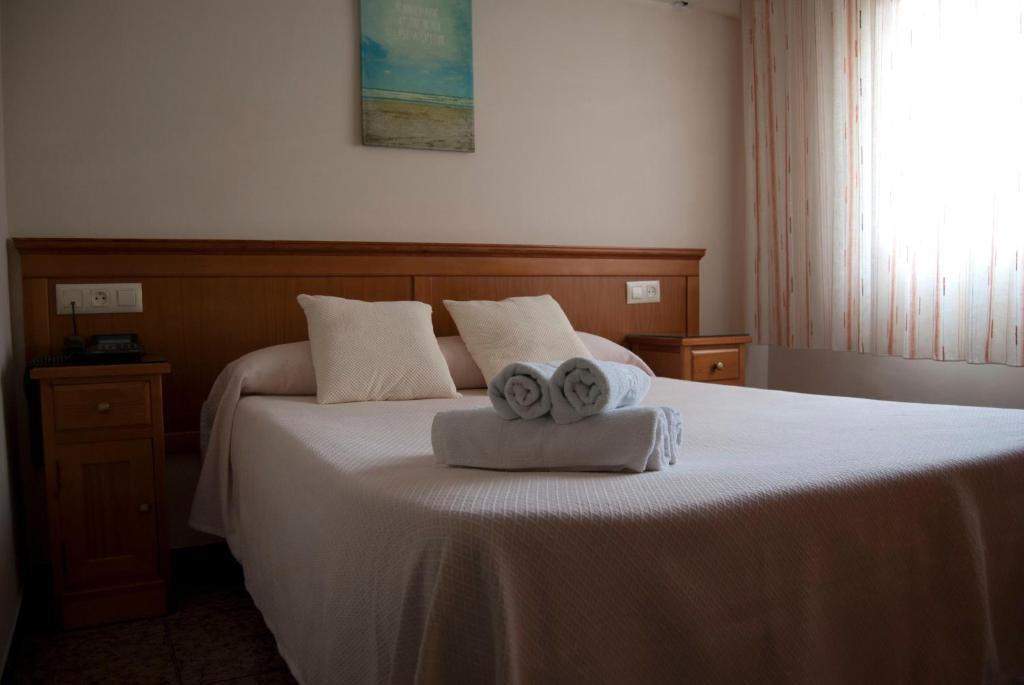 阿尔么丽亚玛丽贝尔旅馆的一间卧室配有一张床,上面有两条毛巾