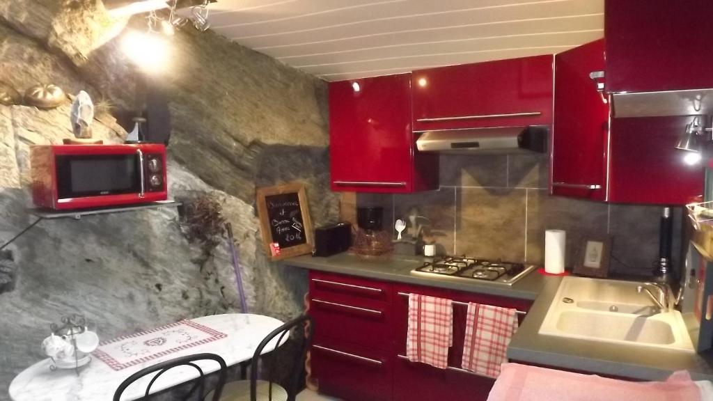 Cantenay-ÉpinardGîte des pêcheurs的一个带红色橱柜和水槽的小厨房