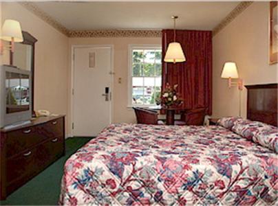 约克镇约克镇汽车旅馆的一间卧室配有一张床、梳妆台和电视。