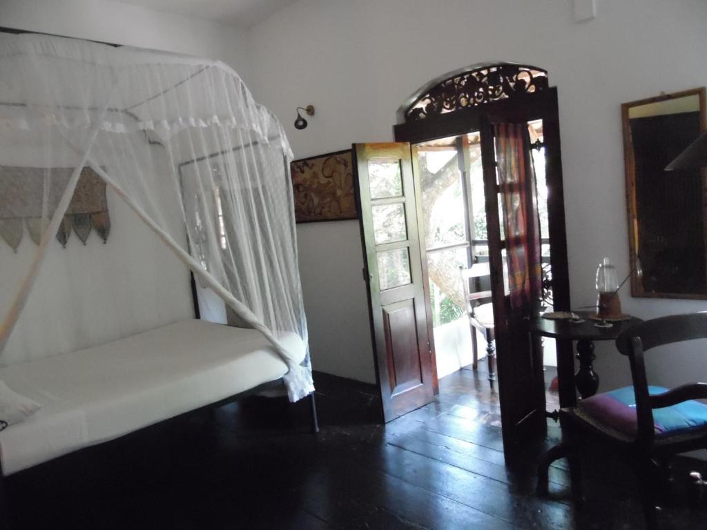 乌纳瓦图纳美梦之家旅馆的一间设有床铺和开放式门的房间