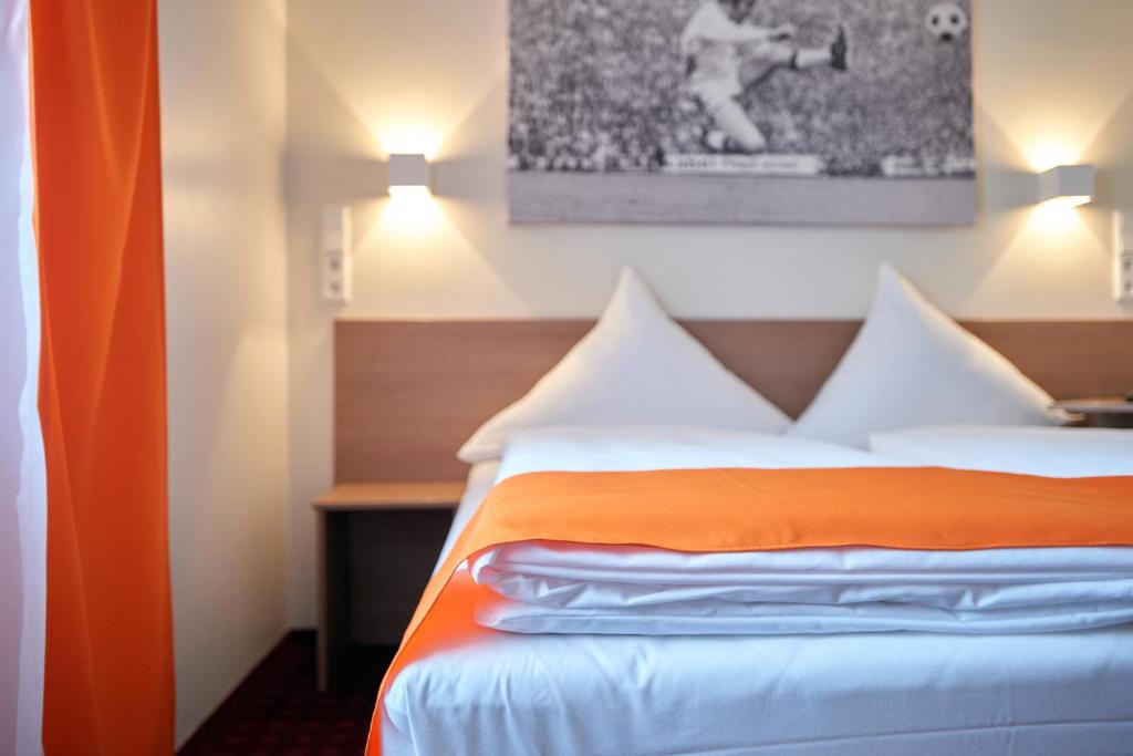 门兴格拉德巴赫门兴格拉德巴赫梦想酒店 的酒店客房,配有带橙色窗帘的床