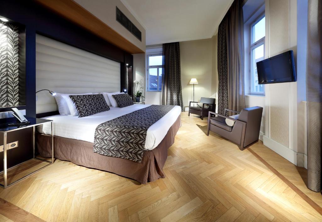 布拉格塔利亚欧洲之星酒店的一间卧室配有一张大床和一台平面电视