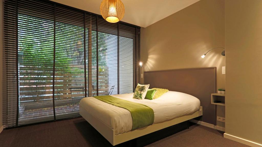 列日列日酒店式公寓的一间卧室设有一张大床和一个大窗户